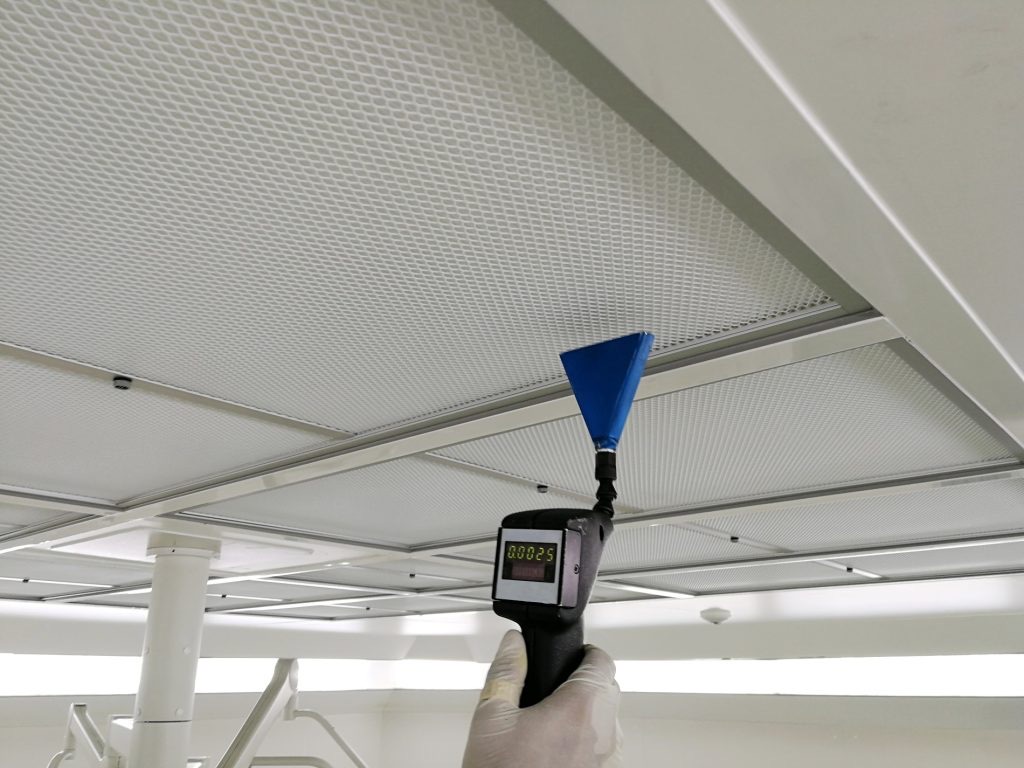 Technician measuring airflow at a ceiling grille